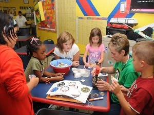 Adult and children making crafts at a table
