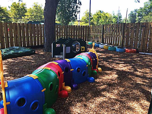 Colorful caterpillar tunnel on a playground with wood chips