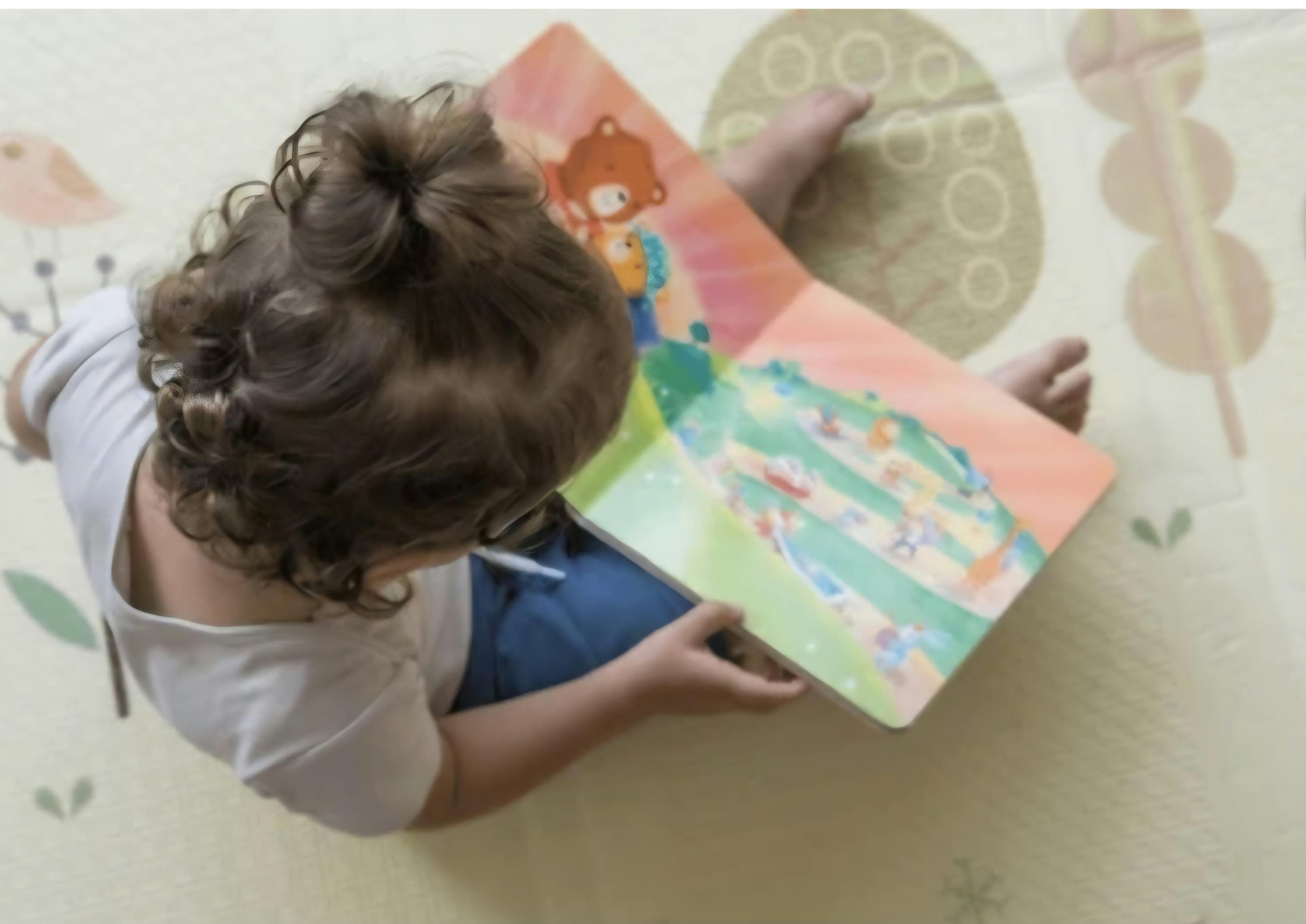 Child on floor reading a book