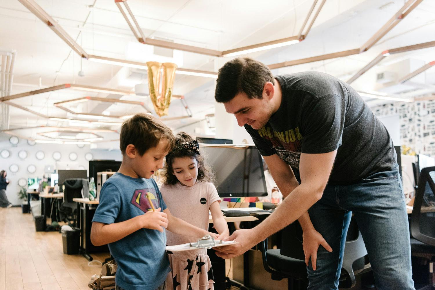Adult and two children looking at a clipboard