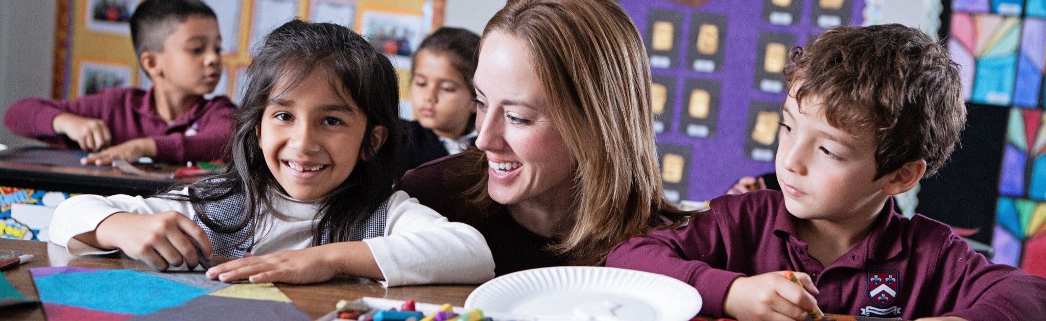 Teacher and children in a classroom working on art projects