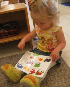 Child sitting on floor looking at a book