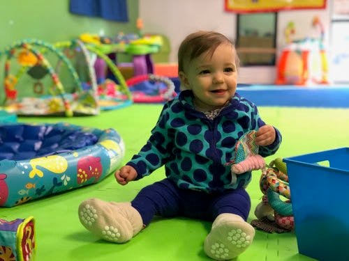 Child sitting on floor with toys