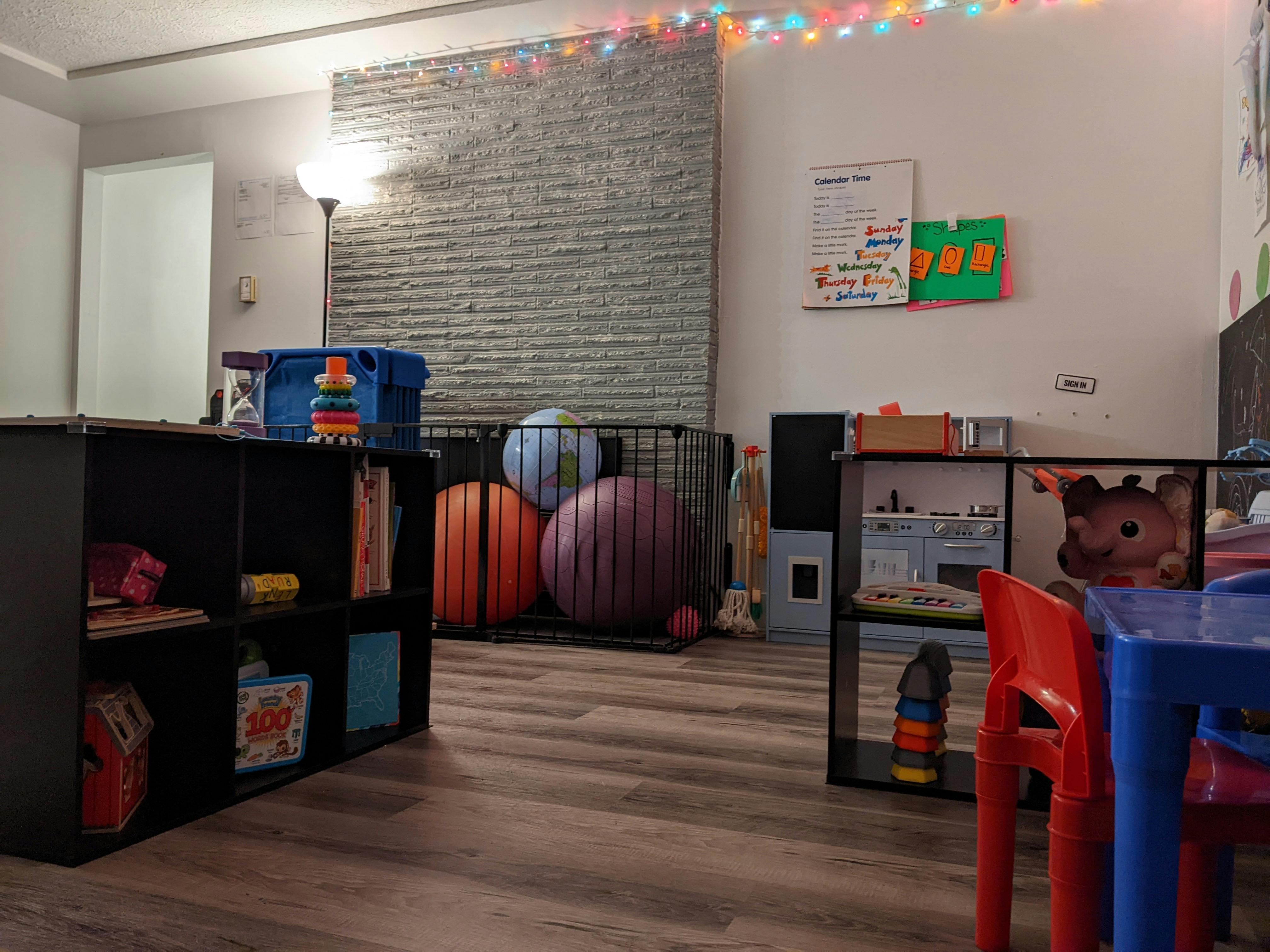 Playroom with shelves, exercise balls in a cage, and small tables and chairs