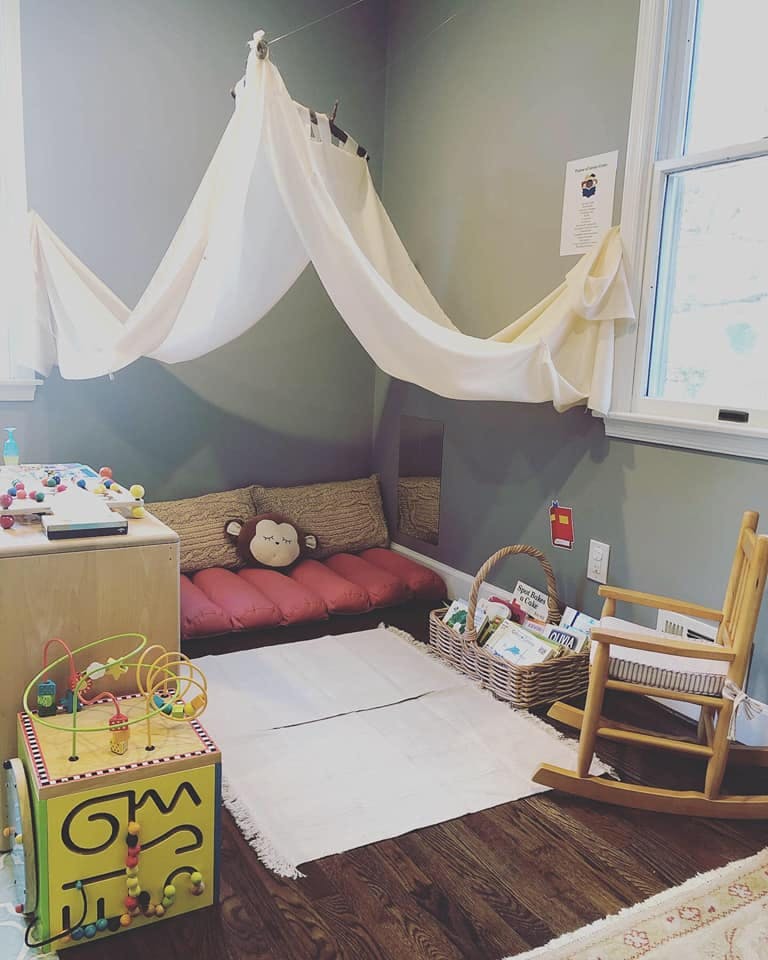 Children's play area with canopy, activity cube, and rocking chair