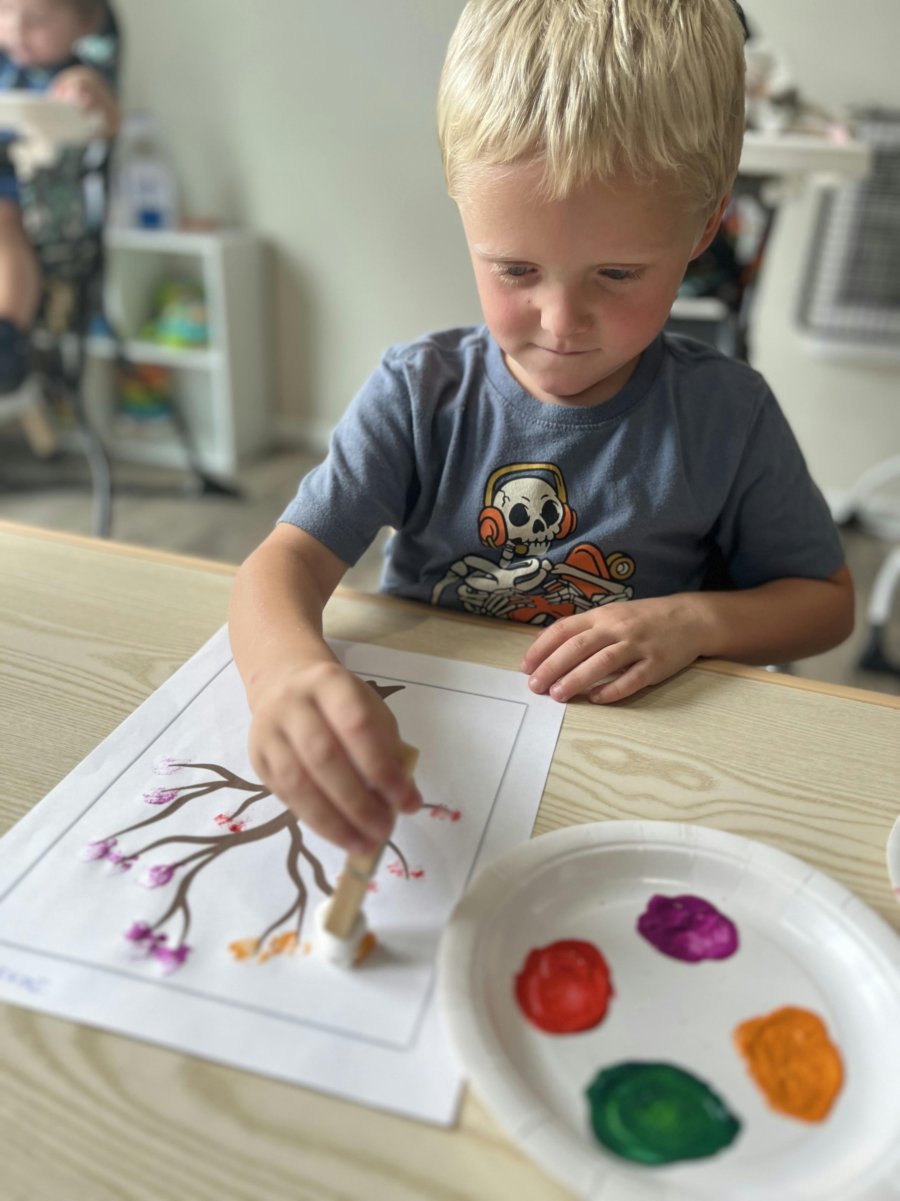 Child painting a tree with colorful dots