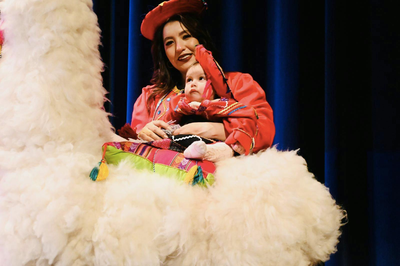 Person in red hat holding a child on a fluffy white object