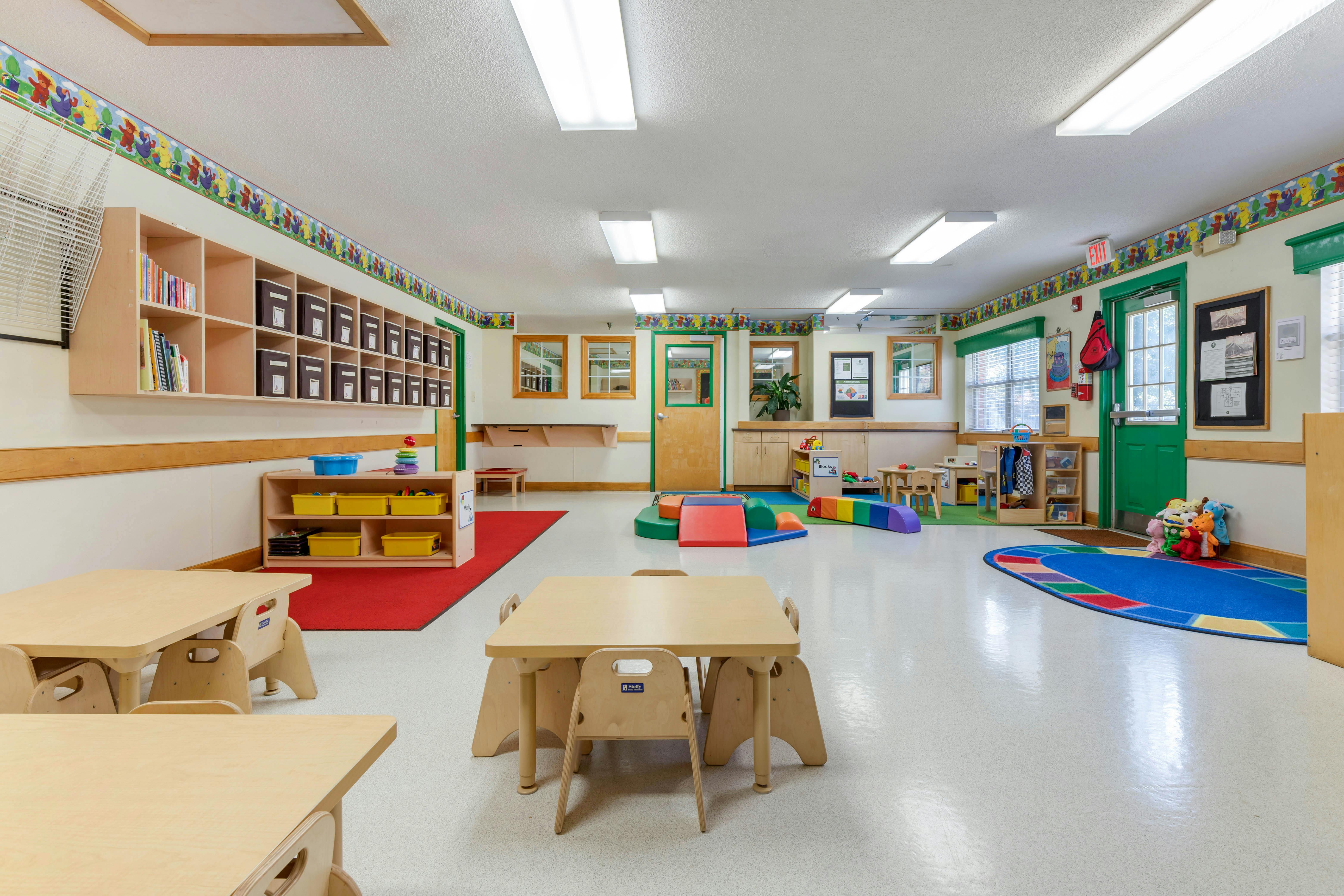 Empty colorful children's classroom with small tables and chairs