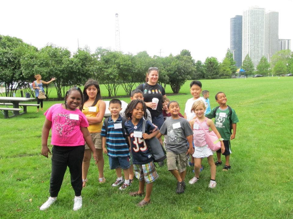 Group of children and adults standing in a grassy field