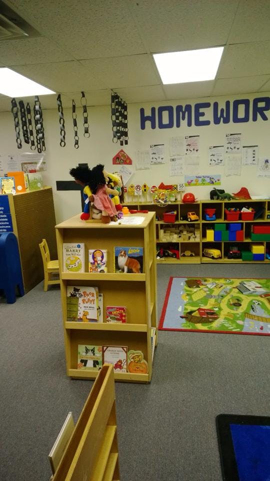 Classroom with a bookshelf, toys, and a rug with a map design