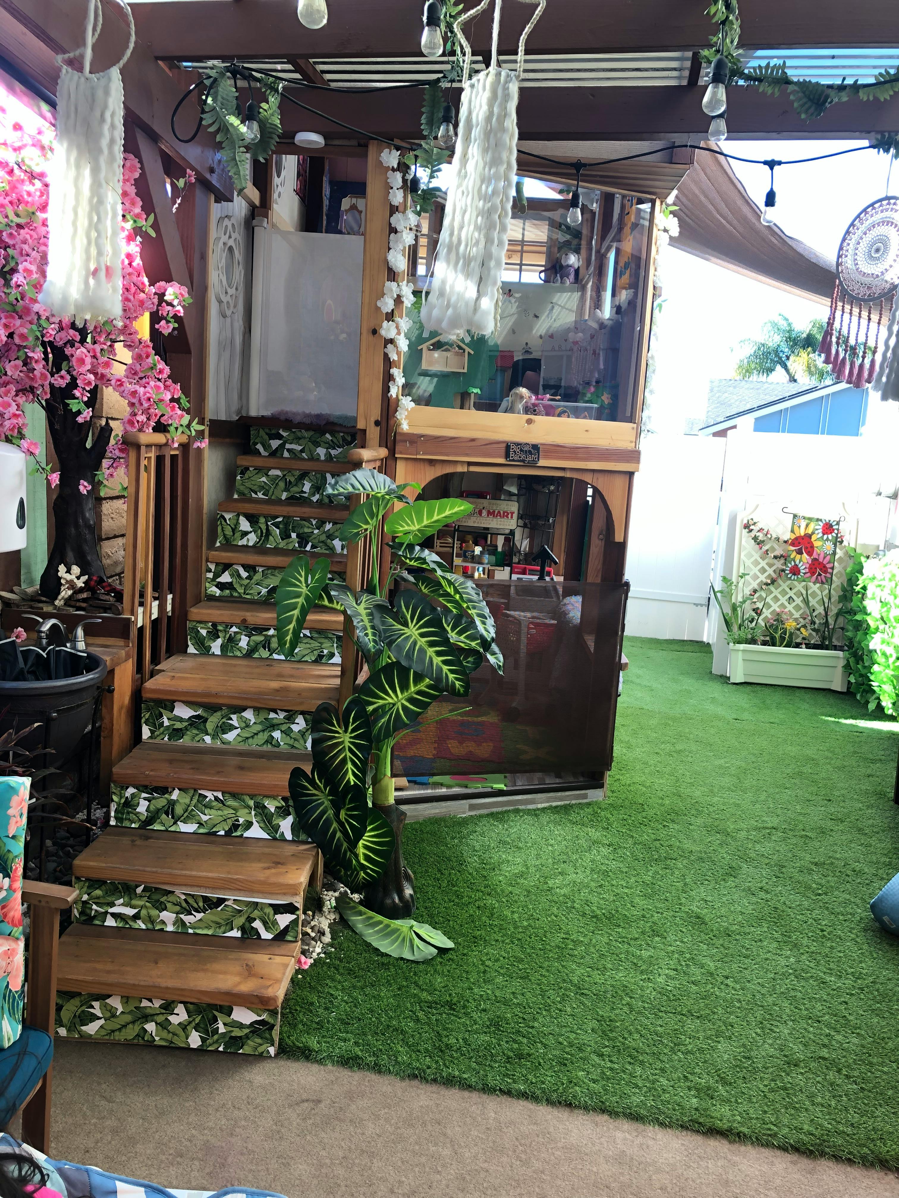 Stairs with leaf pattern risers next to a plant and artificial grass