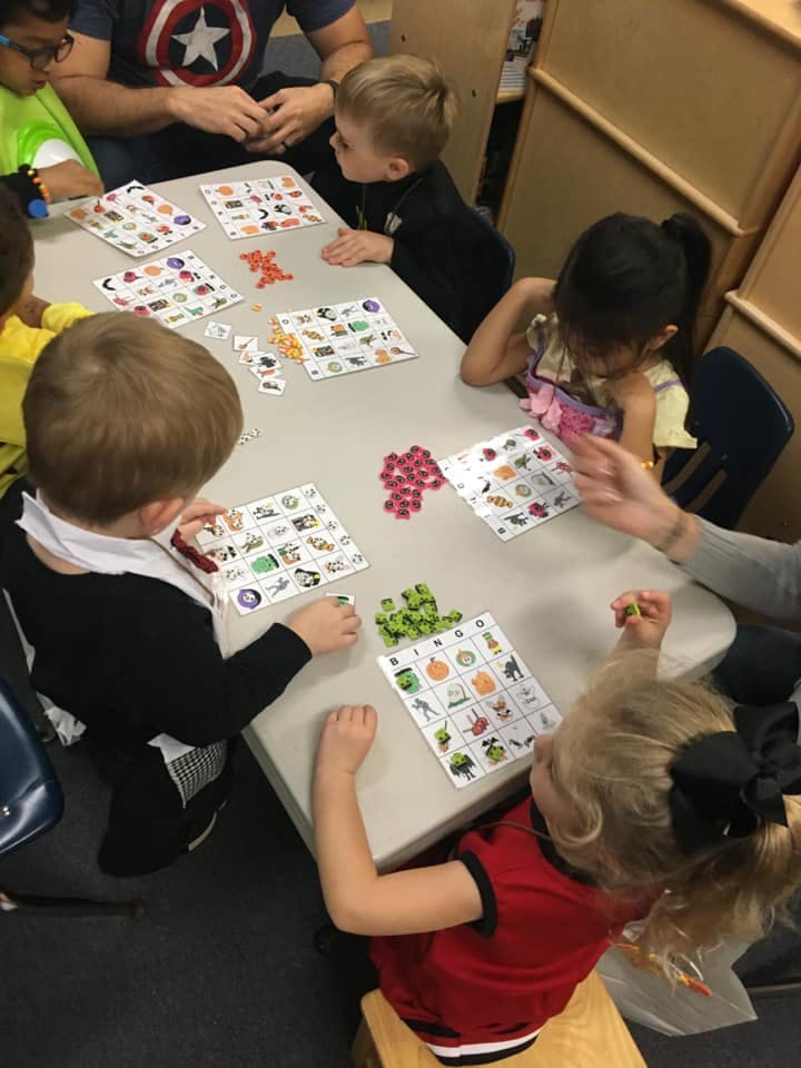 Children and an adult playing a board game at a table