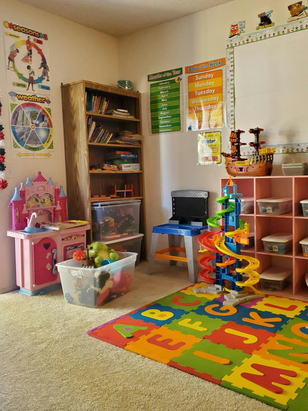 Playroom with toys, bookshelf, and alphabet mat