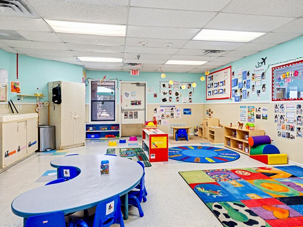 empty preschool classroom with play mats and kidney-shaped table