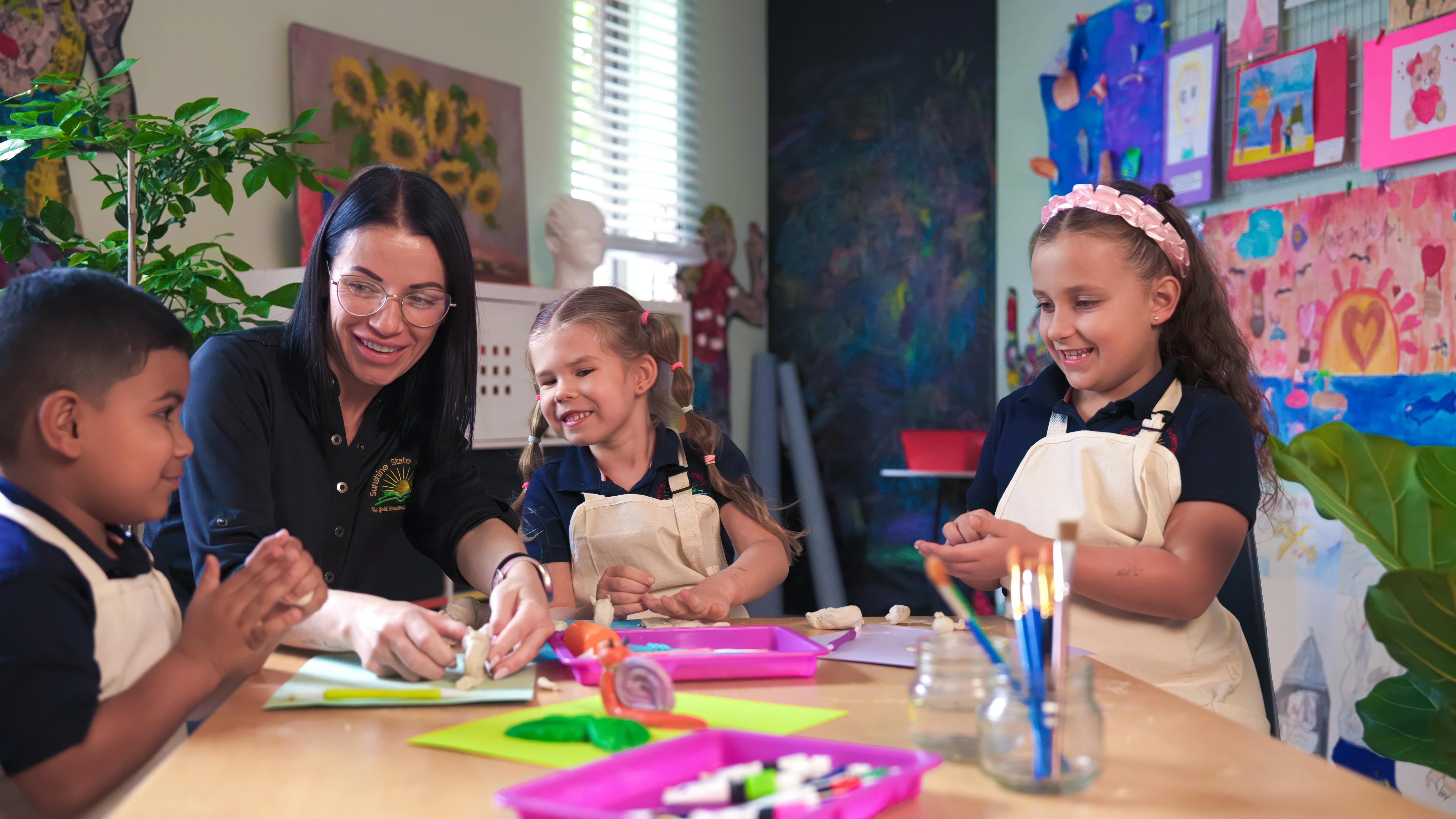 Adult and three children making crafts at a table