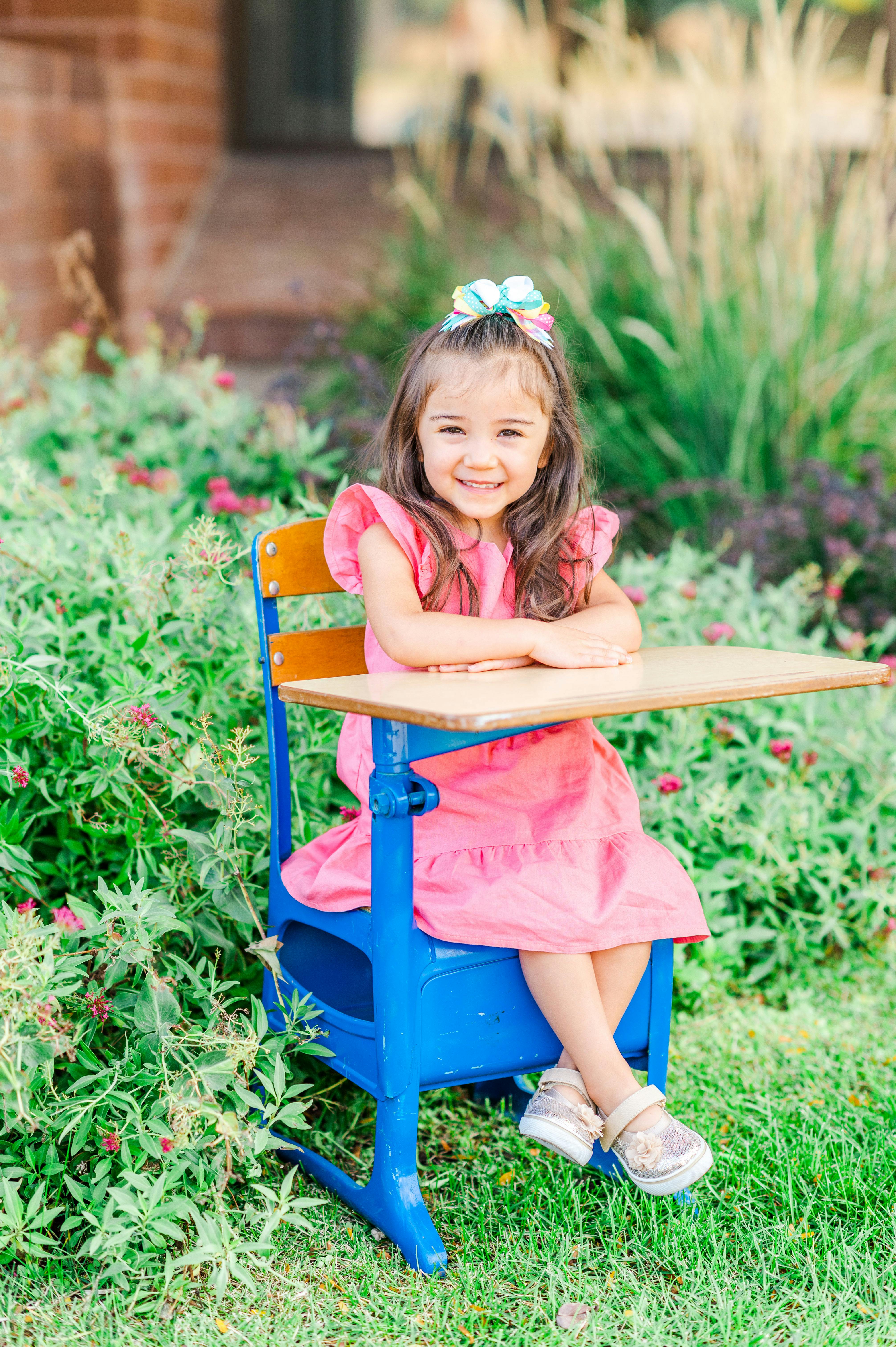Child sitting at a school desk outdoors