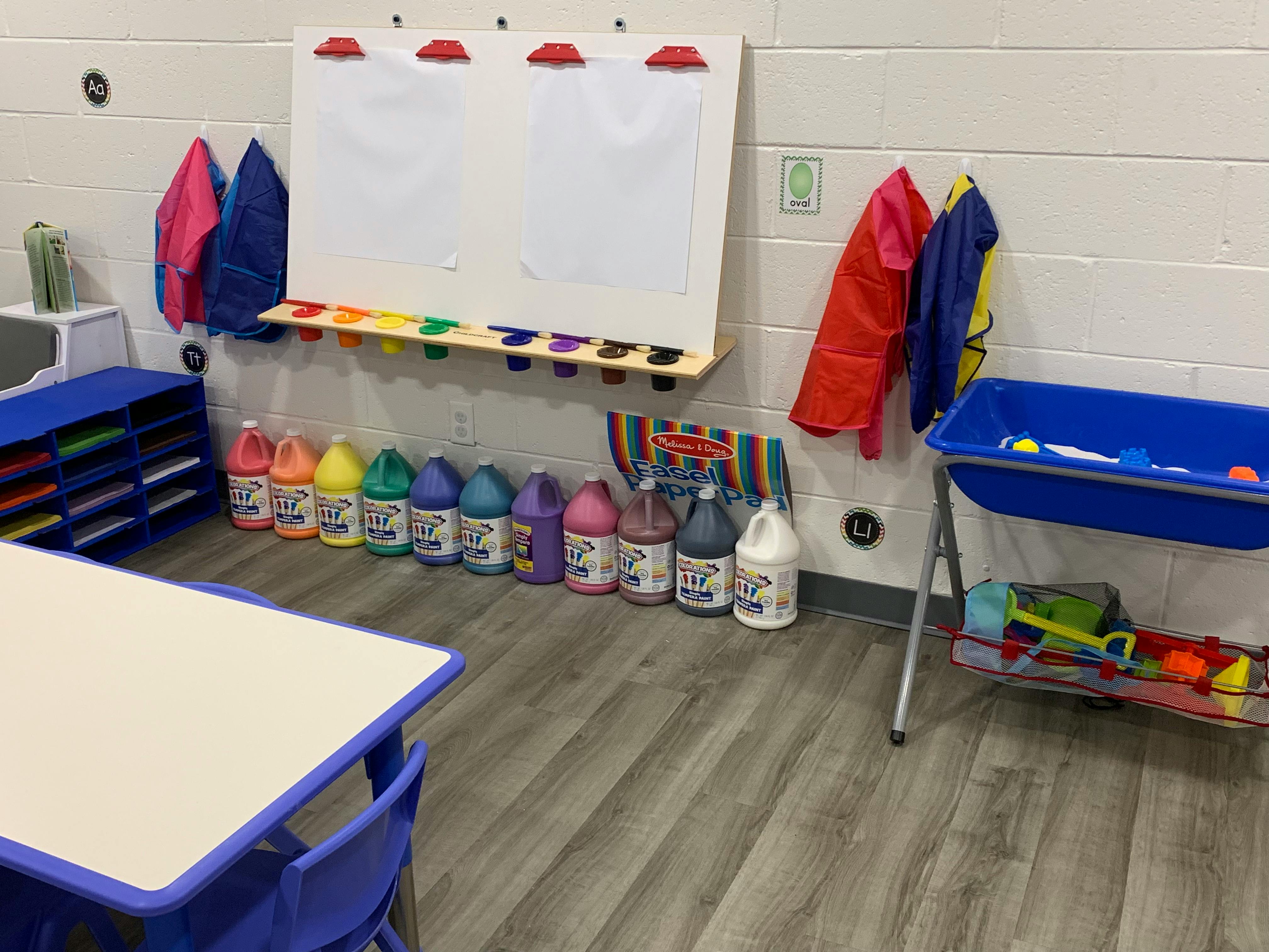 Classroom with whiteboard, art supplies, and sensory table