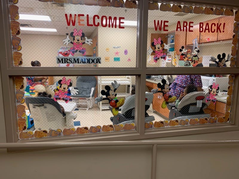 Window with "Welcome" and "We are back!" signs, decorated with cartoon characters
