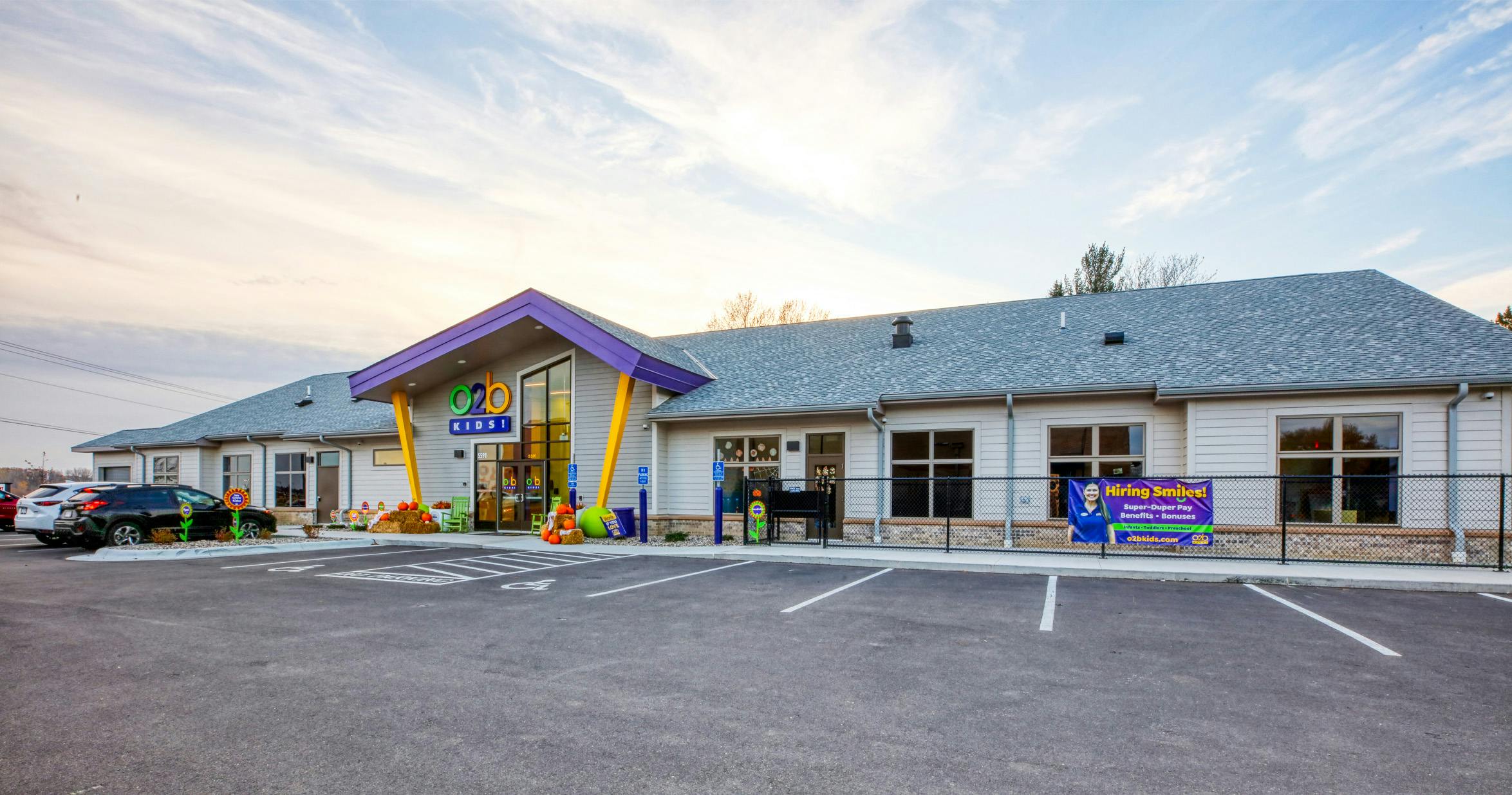 Exterior of O2B Kids building with a sign that reads "Hiring Smiles!"