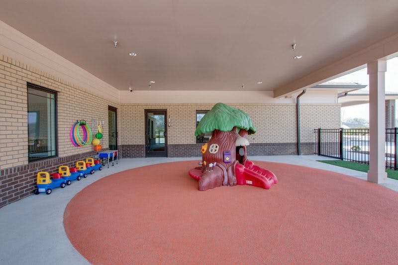 Outdoor play area with a tree-shaped slide and toy train