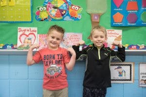 Two children standing in a classroom