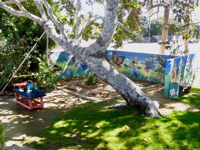 Tree with a painted mural and a small table in a park