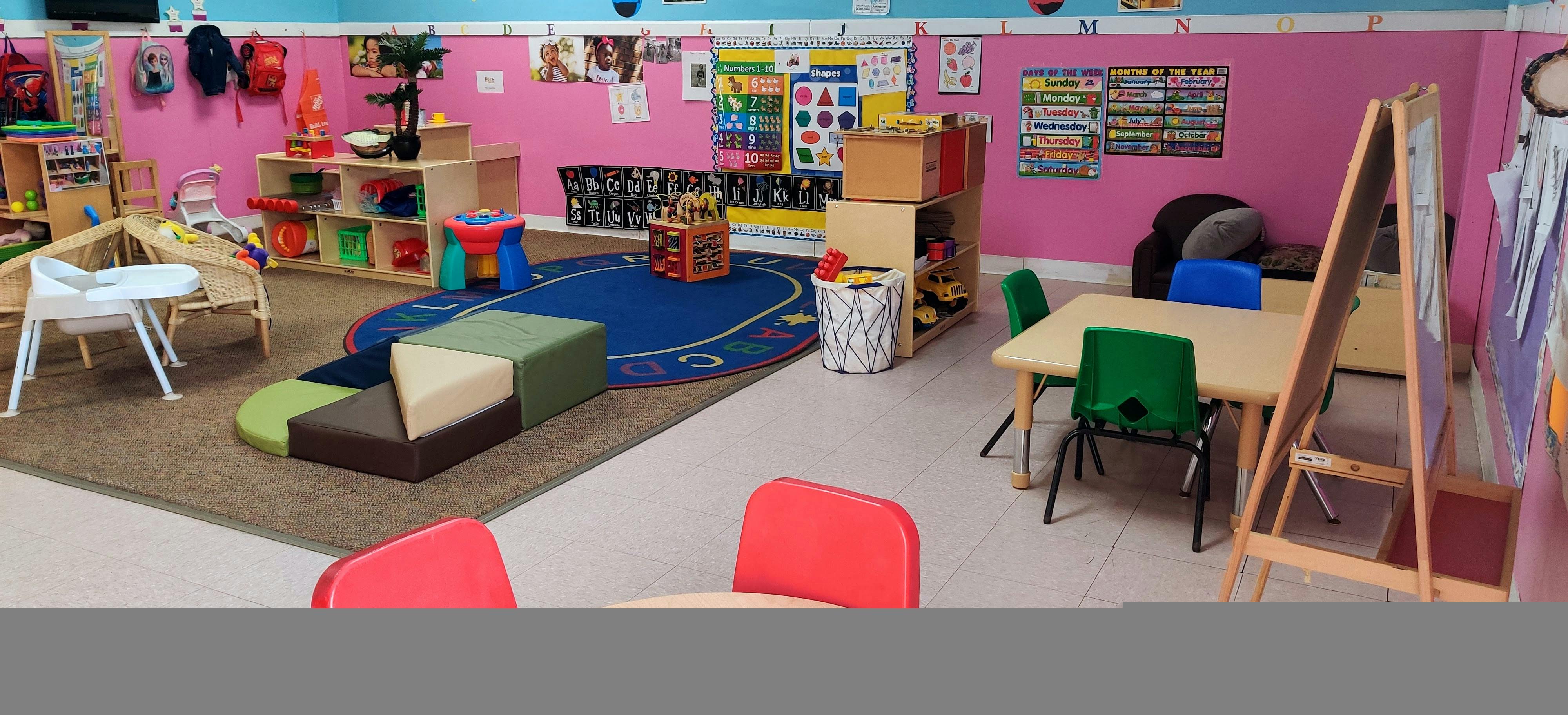 Classroom with small tables, chairs, and play mats