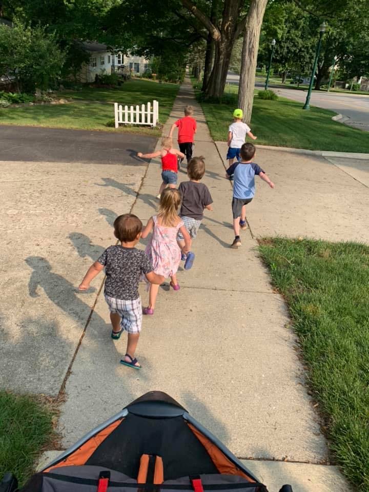 Group of children running on a sidewalk