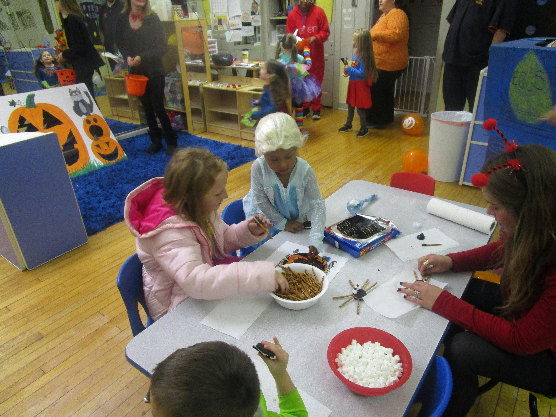 Children at a table making crafts with snacks