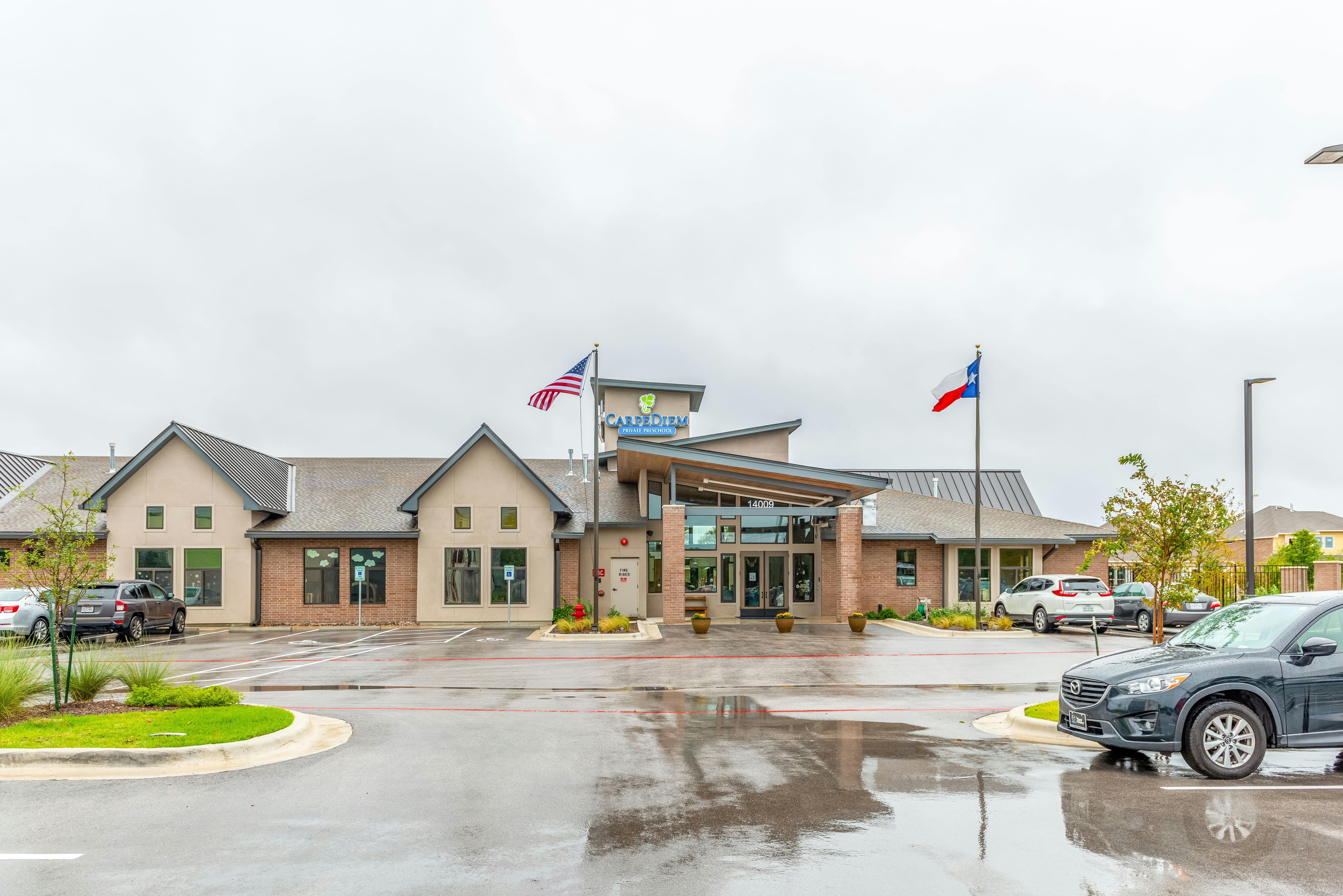 Building exterior with flags and a parking lot