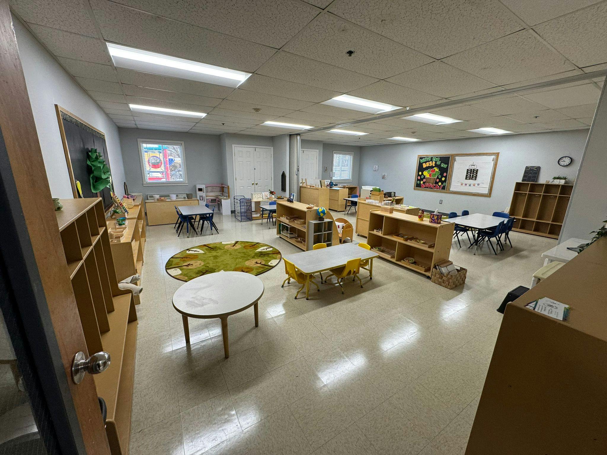 Empty classroom with tables, chairs, and shelves