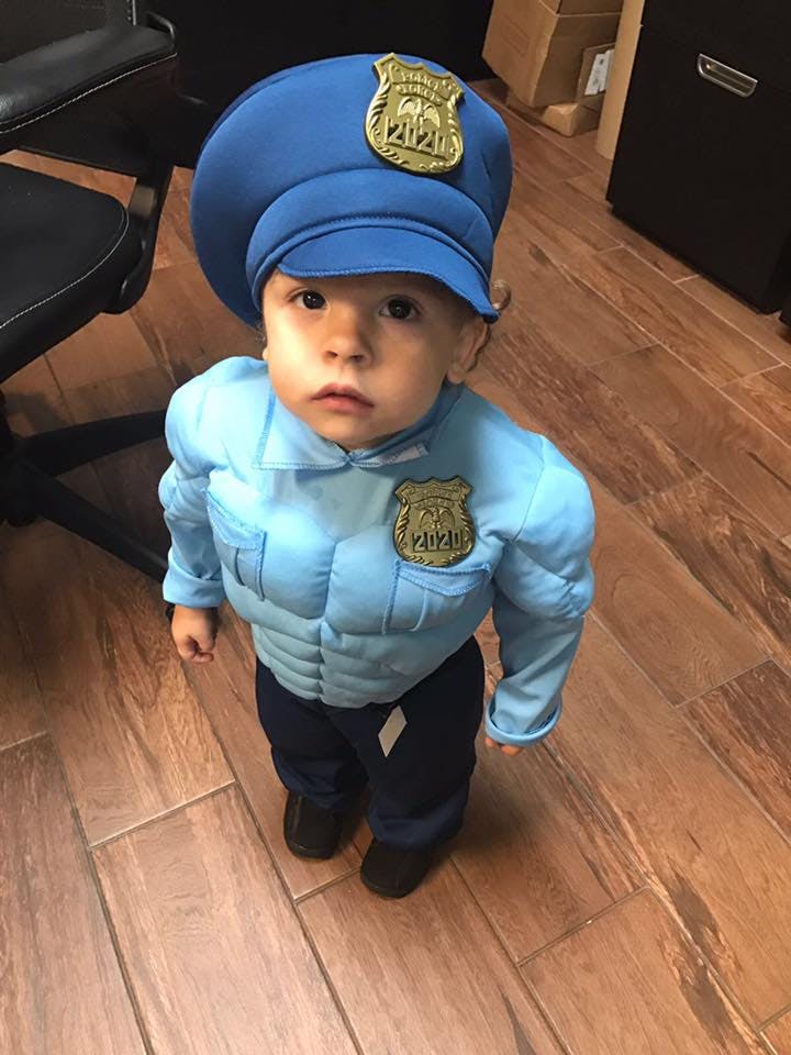 Child in a police officer costume with a hat and badge