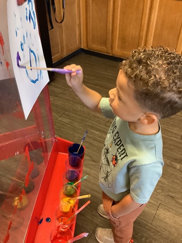 Child painting on an easel