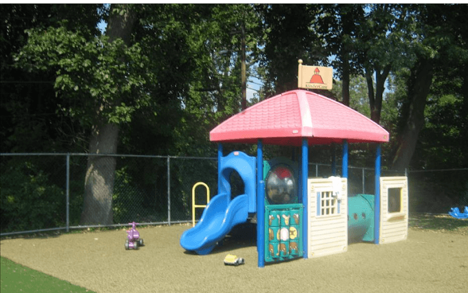 Empty playground with a blue slide, playhouse, and climb-through tunnel