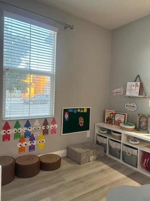 Classroom with colorful crayon cutouts, a chalkboard, and a bookshelf