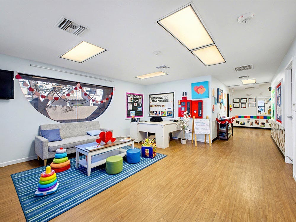 Children's classroom or play area with a sofa, rug, and educational displays