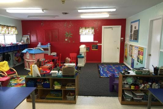 Classroom with red walls, toys, and shelves