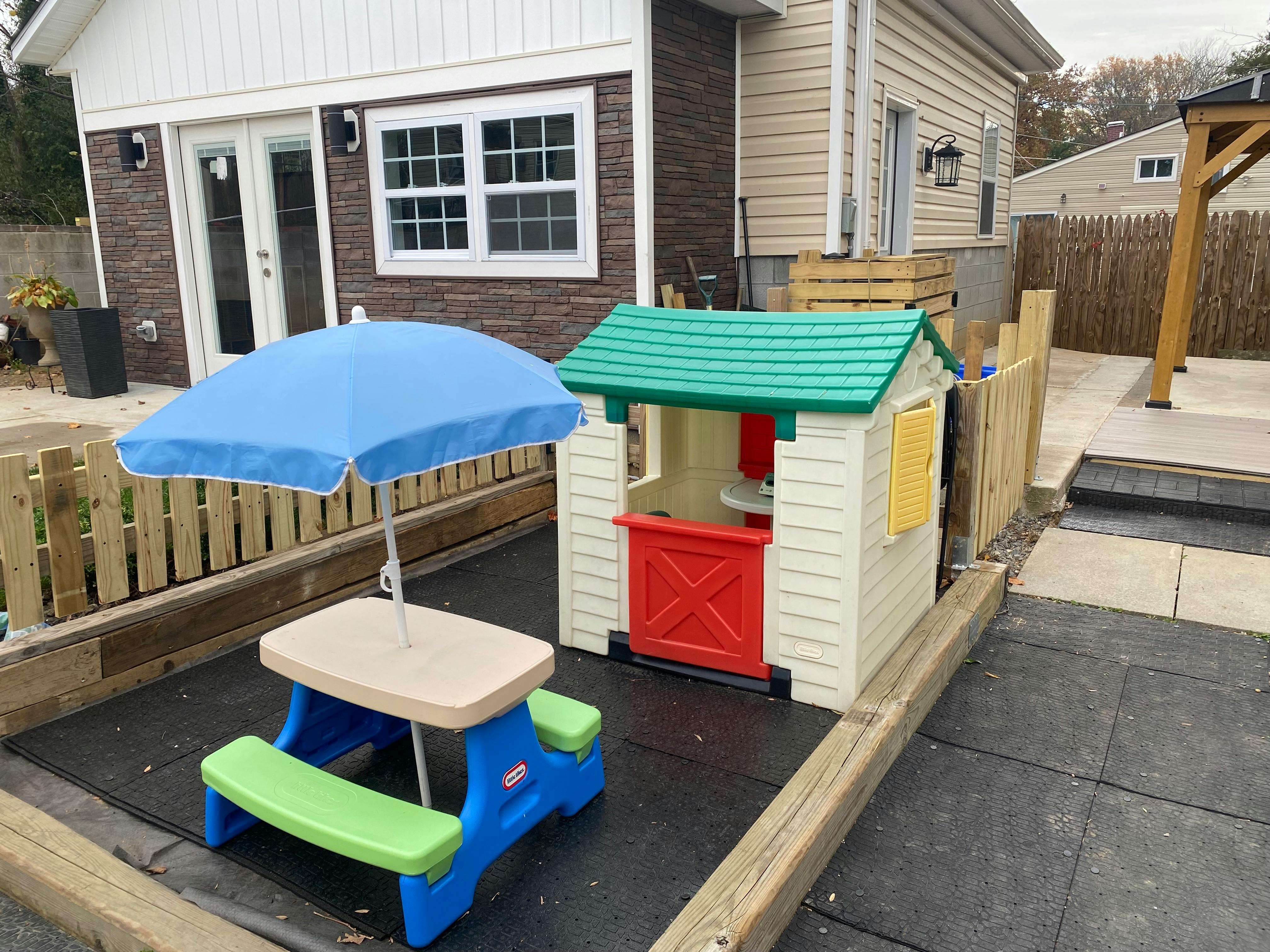 Children's playhouse and picnic table with umbrella