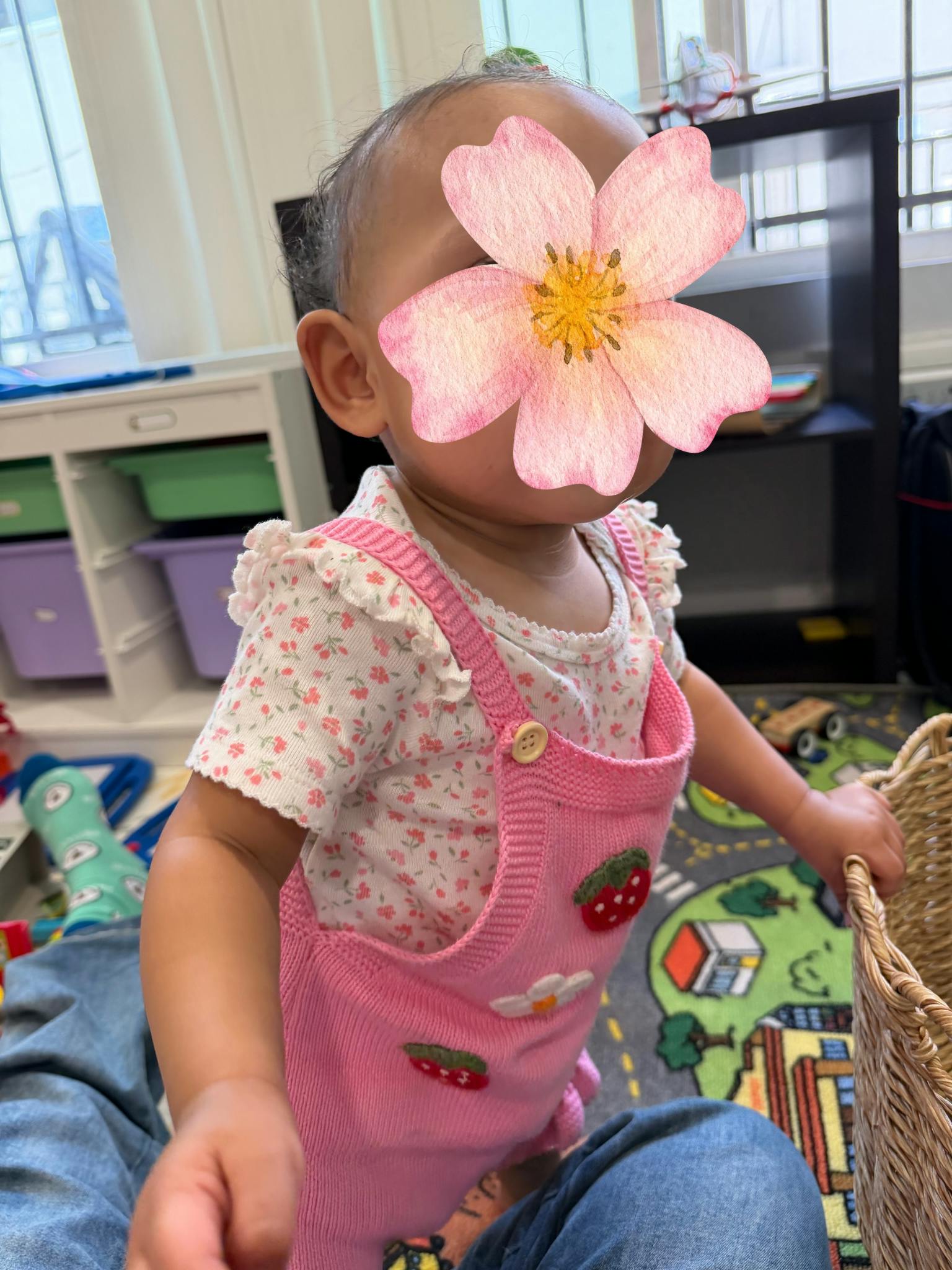 A child in a playroom standing next to a wicker basket
