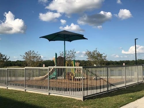 Playground with a fence and umbrella