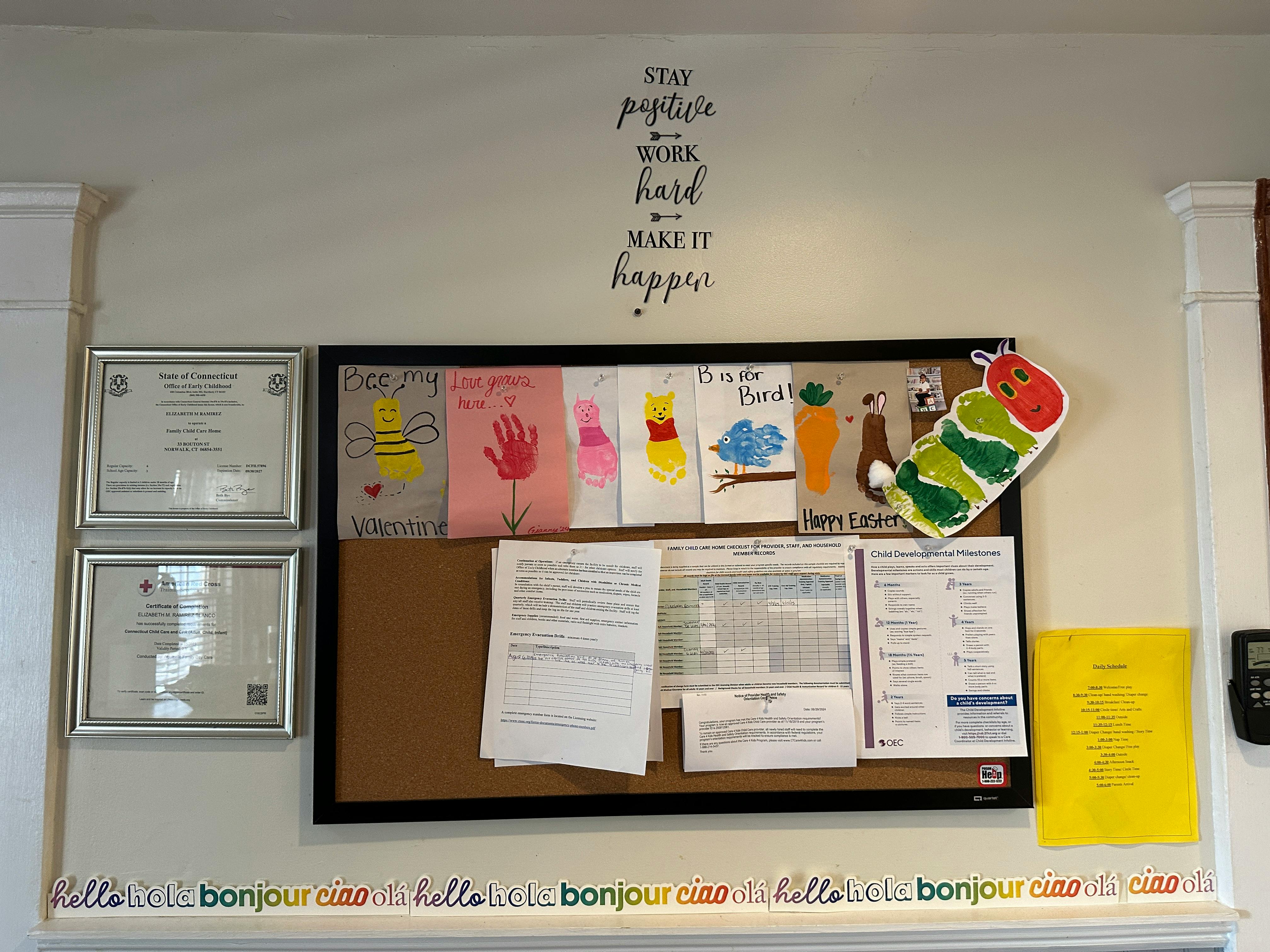Bulletin board with children's drawings, documents, and a caterpillar cutout
