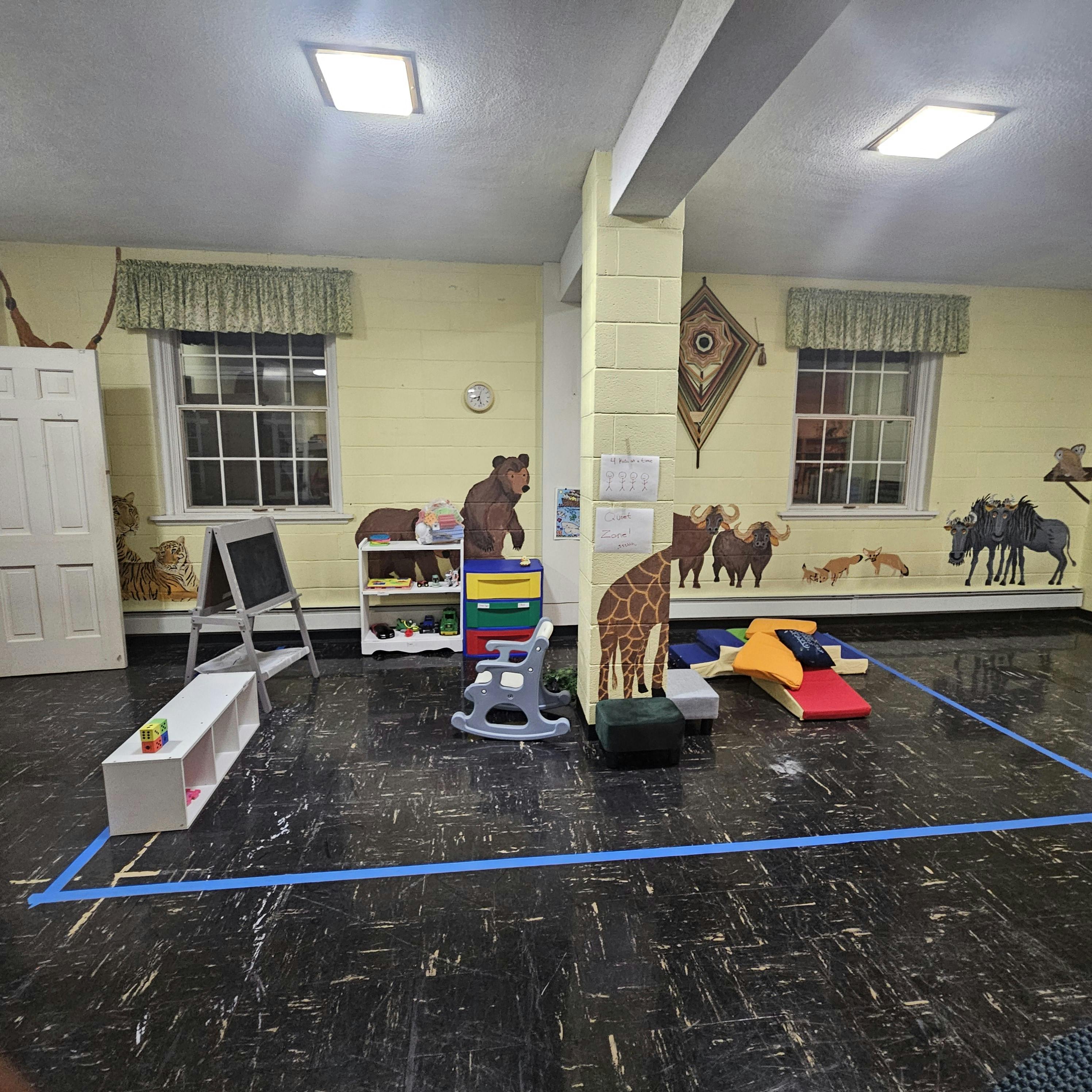 Playroom with animal cutouts on the wall and various toys