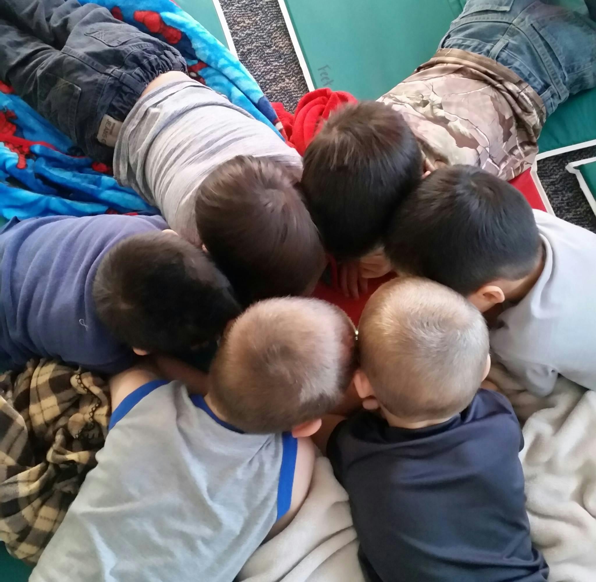 Group of children huddled together looking down