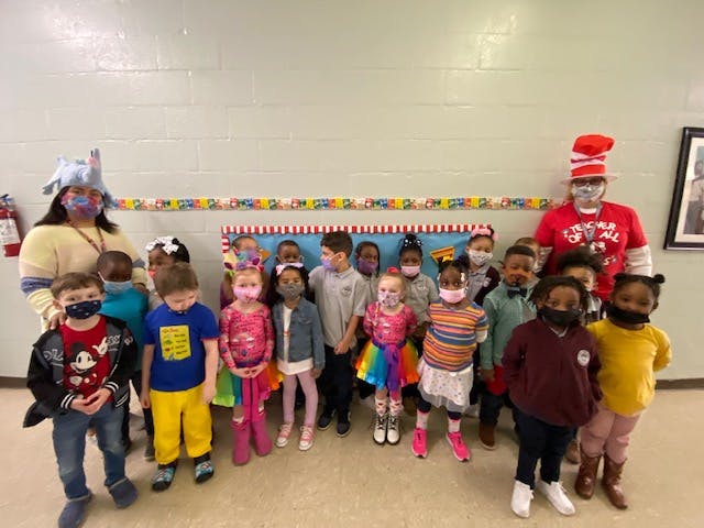 Two adults and multiple children posing for a photo indoors
