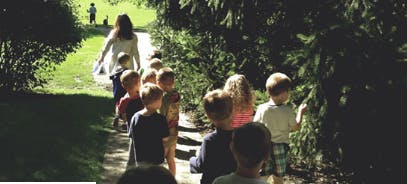 Adult leading a line of children on a path