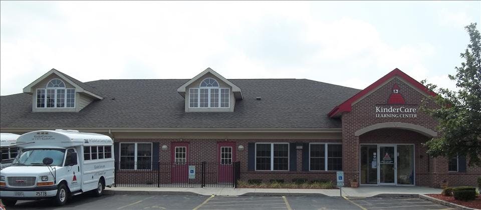 KinderCare Learning Center building with a white shuttle bus parked outside