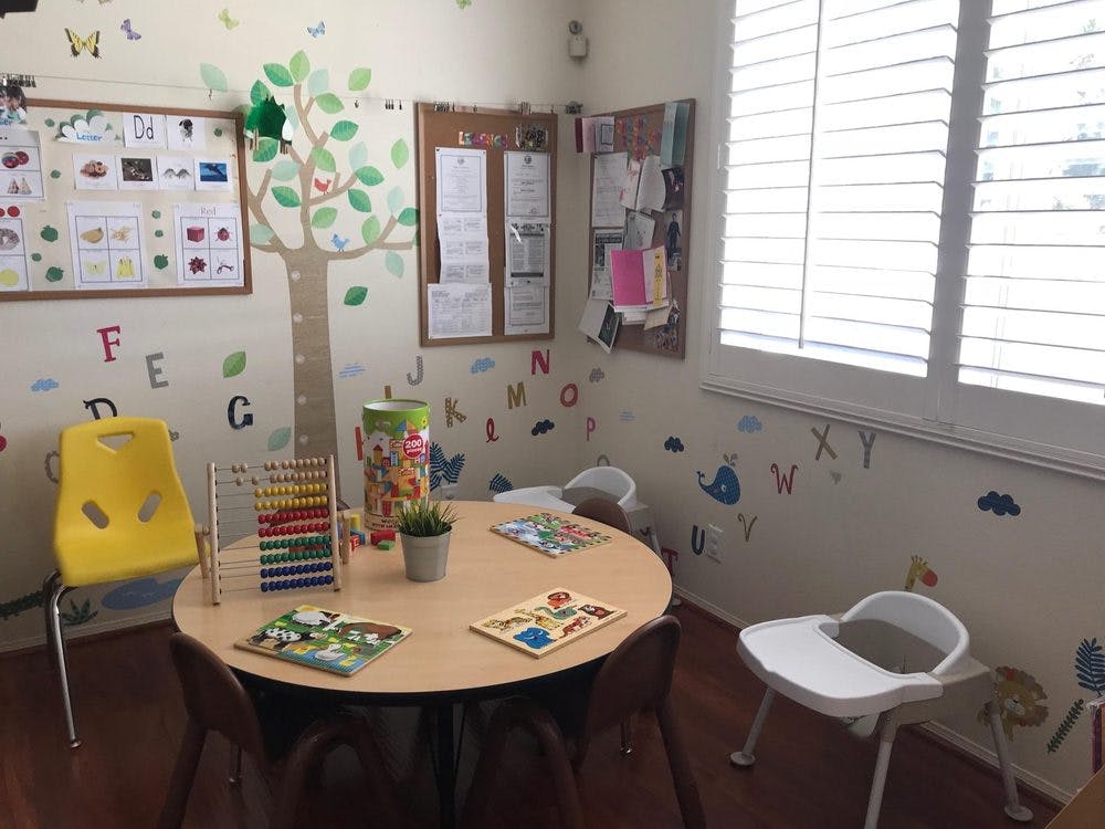 Child's play area with a round table, chairs, and educational decorations