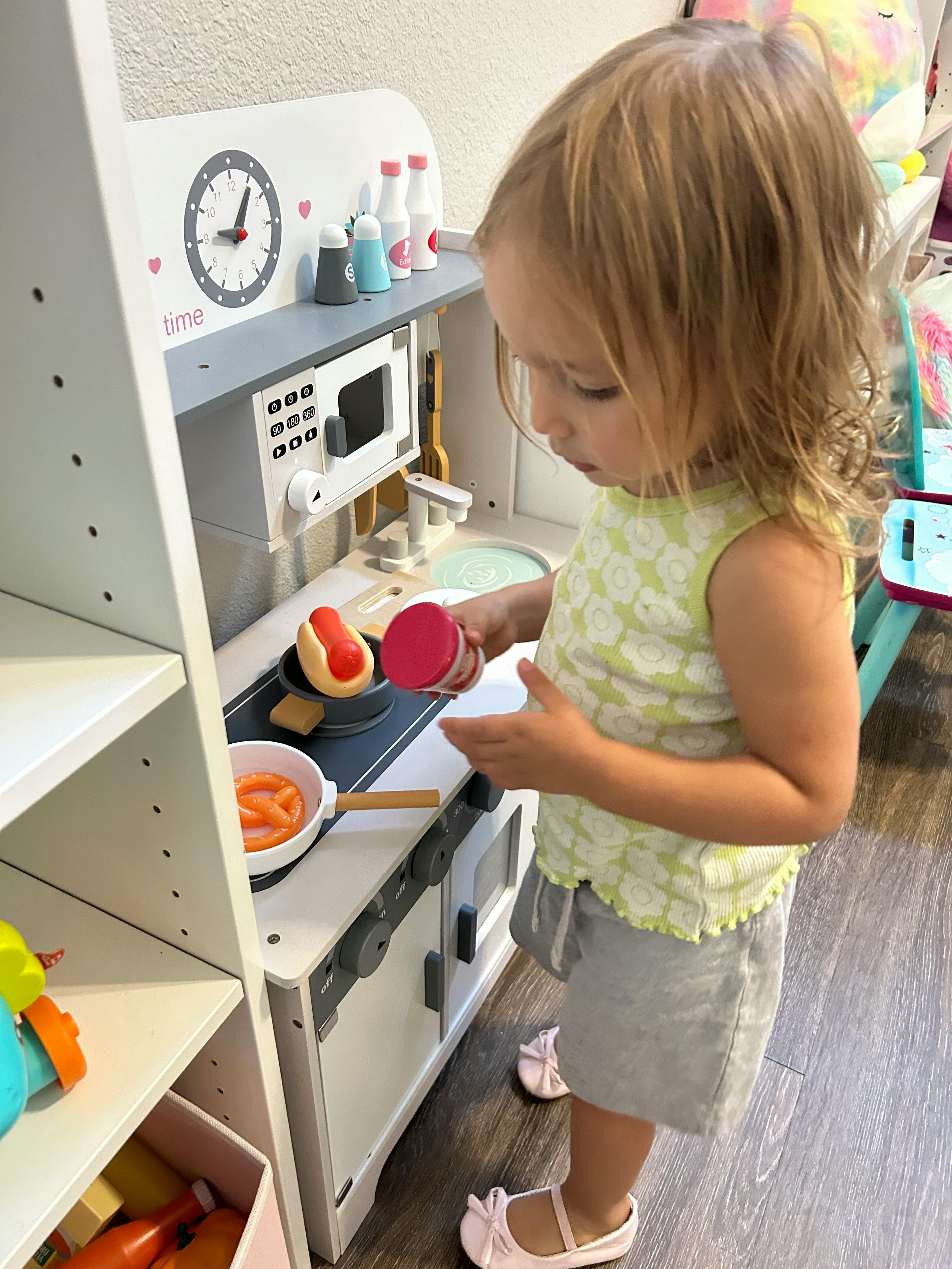 Child playing with a toy kitchen
