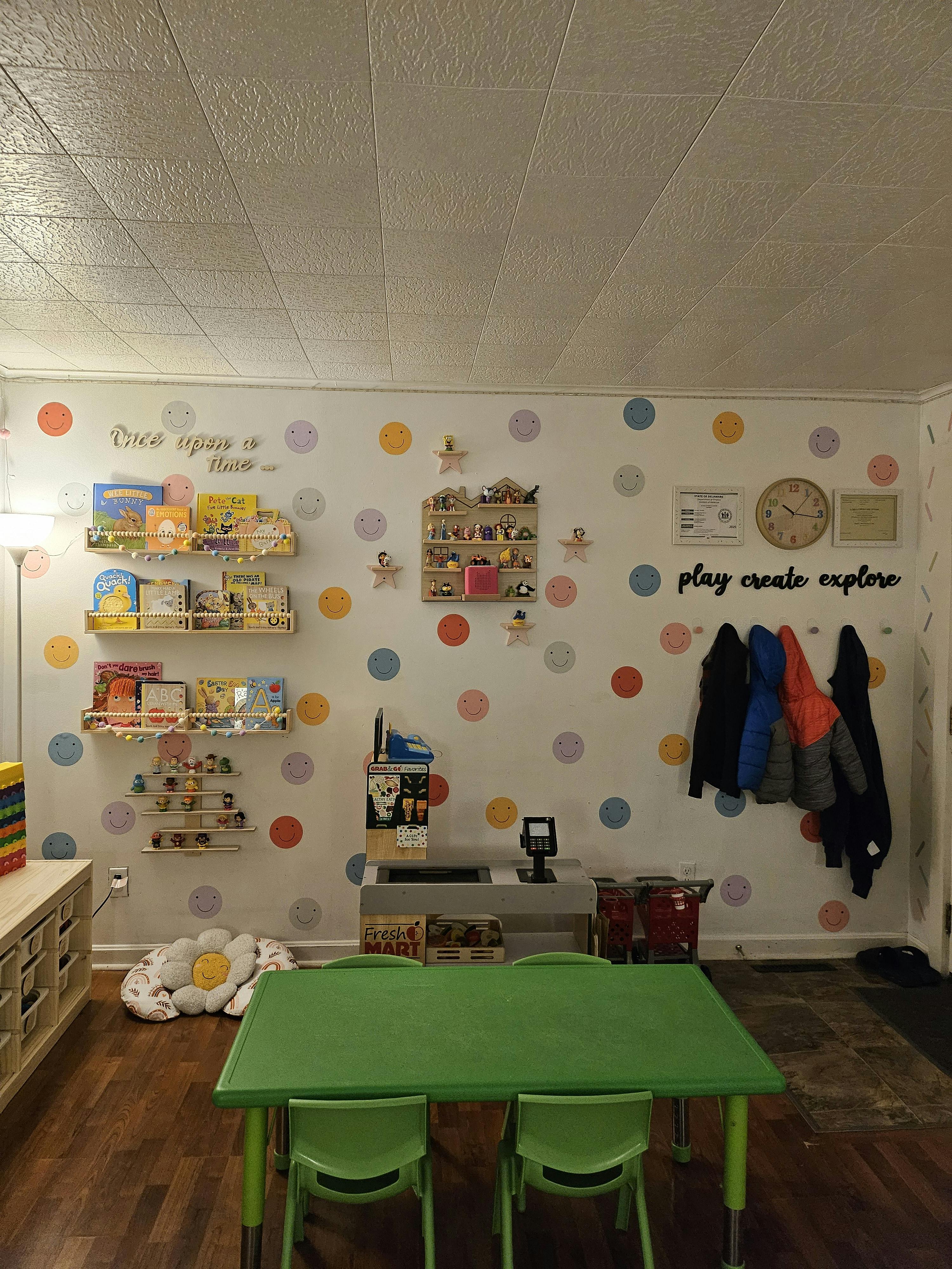 Classroom with polka dot walls, bookshelves, and a green table with chairs