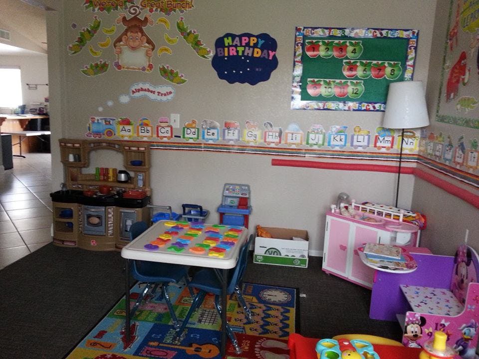 Playroom with a toy kitchen, small table, and various toys